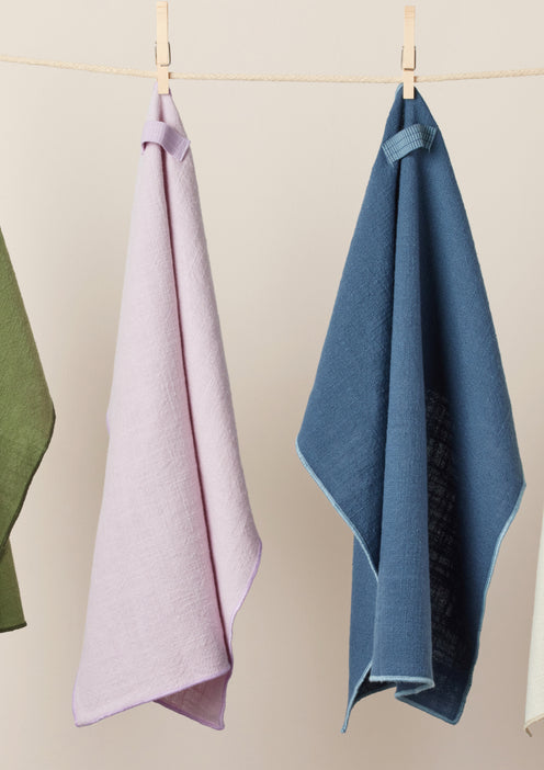 Green, purple, and blue Loop Napkins hanging from a clothesline
