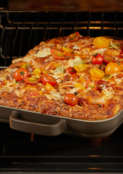 Pizza cooking in a black Mini Griddle Pan in the oven