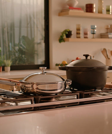 A chrome Titanium Always Pan Pro and black Perfect Pot on the stove in the kitchen