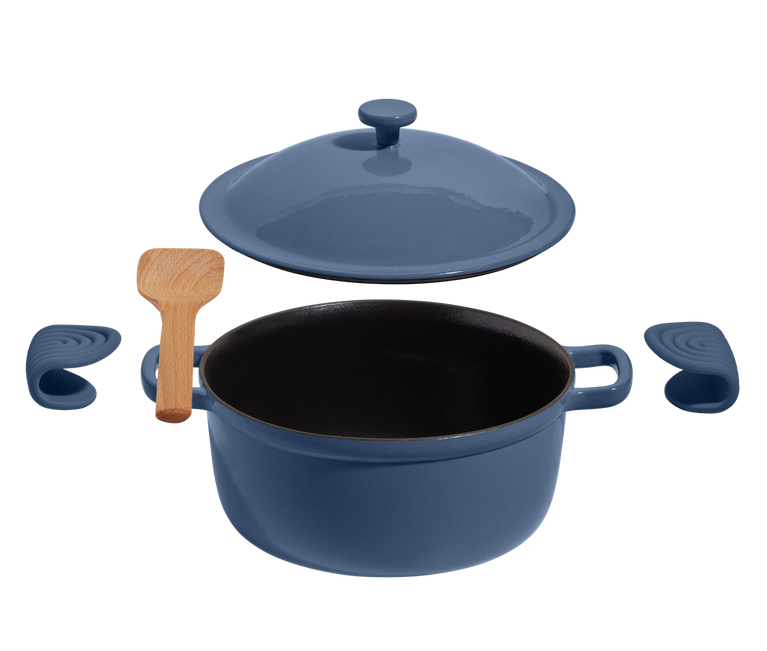 A blue Dutch oven with a matching lid, two silicone handle covers, and a wooden spatula arranged on a white background.