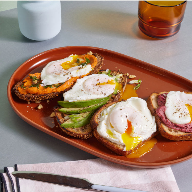 Terracotta serving platter with poached eggs on toast