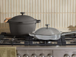 Two cookware items on a gas stove with a neutral background