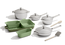 A set of white cookware and green bakeware including pots, pans, baking dishes, and two utensils, arranged on a white background.