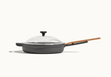 A gray nonstick skillet with a wooden handle and a clear glass lid, shown against a plain white background.