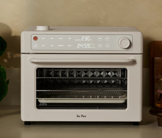 Our Place countertop oven in cream with a digital display showing 230 degrees and 24:59.