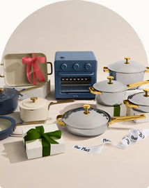 Collection of cookware with decorative bows and gift boxes on a beige background