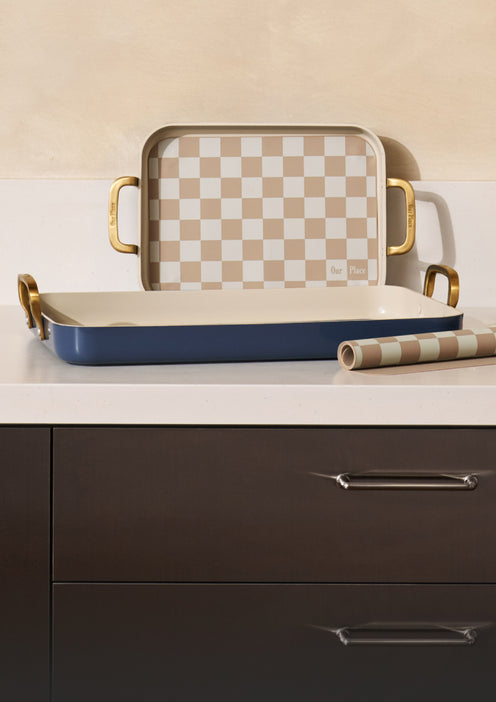 Set of trays with checkered top and blue base on a kitchen counter.