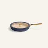 Blue frying pan with a beige lid on a white background
