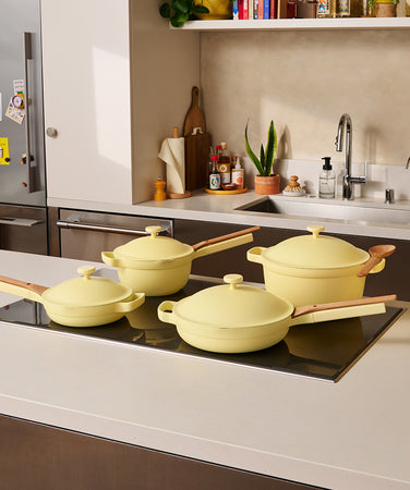 Set of yellow cookware with food on a white background