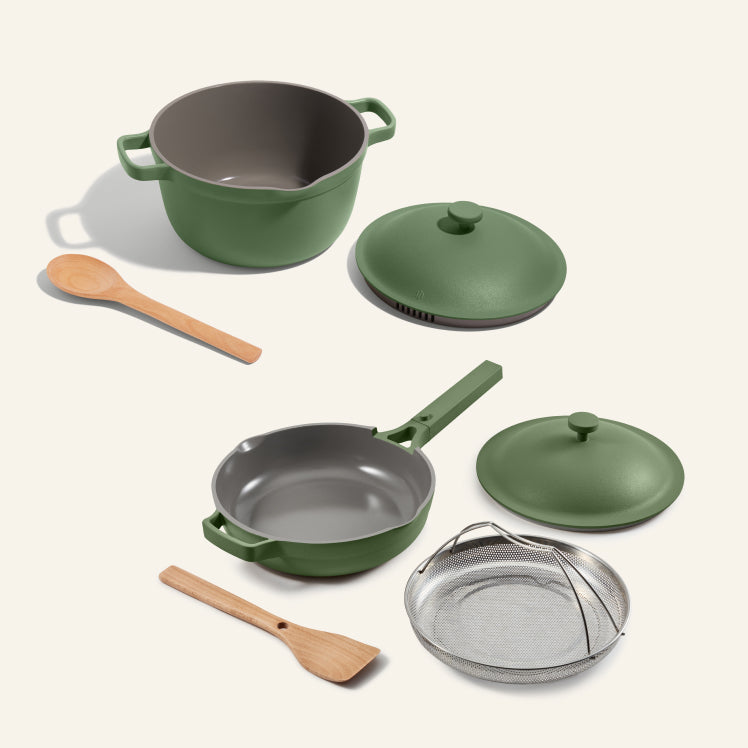 Set of green cookware with gray interior on a white background