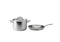 A stainless steel pot with a lid and handles next to a stainless steel frying pan with a long handle, both on a plain white background.