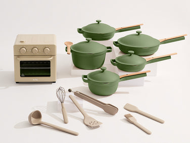 Set of green cookware and kitchen utensils on a white background