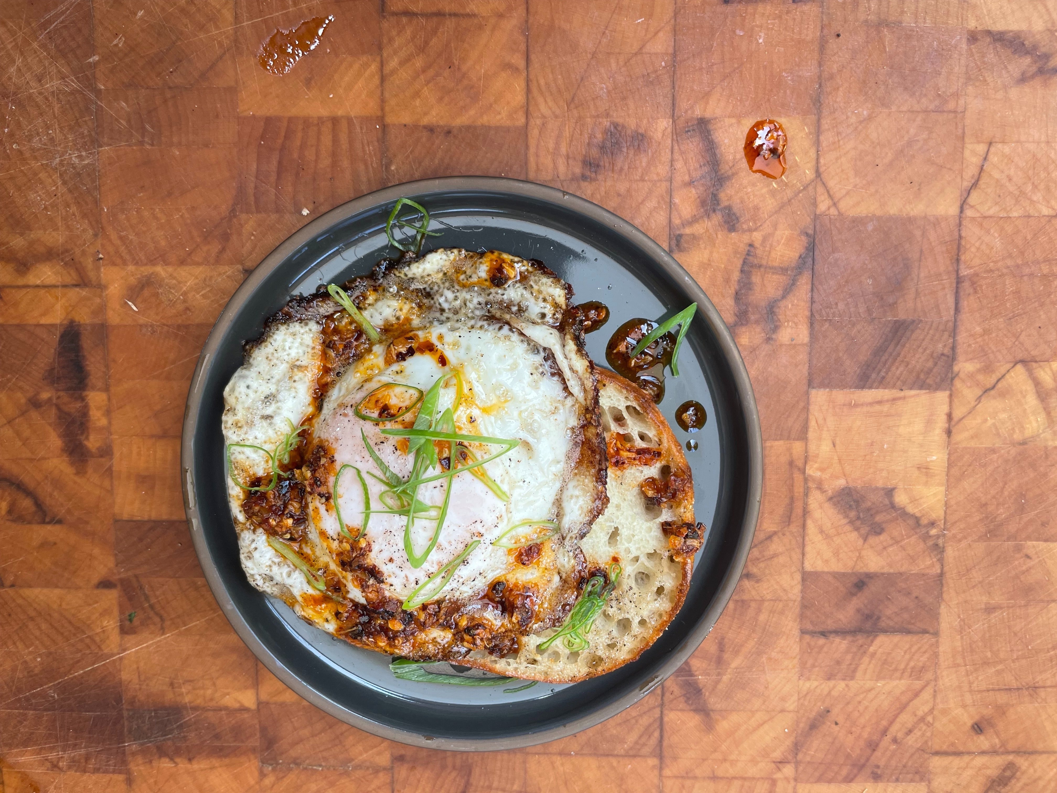 A fried egg cooking in a cast iron pan