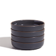 Stack of dark gray ceramic bowls on a white background