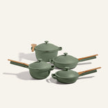 The Cookware Set includes four green nonstick pieces with wooden handles and matching lids, arranged on a light background, echoing the style and versatility of the Always Pan and Perfect Pot.