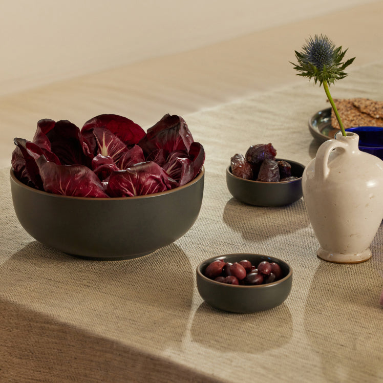 black serving bowl and tiny bowls on table