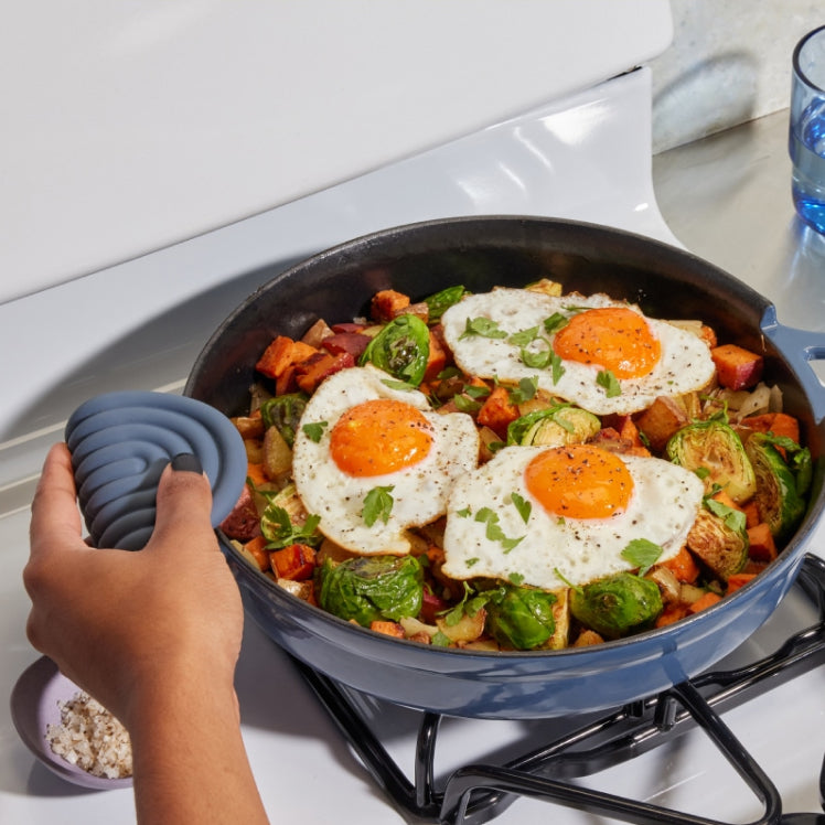 Blue Hot Grips used on the handles of a blue Cast Iron Always Pan cooking an egg dish