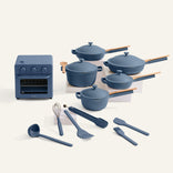 Set of blue ceramic cookware and kitchen tools on a white background