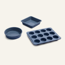 Wonder Oven Pro Bakers Kit: set of four blue PFAS-free, nonstick pans—1 round cake pan, 1 square cake pan, and 12-cup muffin tray on plain background.