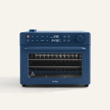 Wonder Oven Pro: Blue countertop oven with digital display for temp and time, top-left control knobs, and a clear front door revealing multiple racks inside.