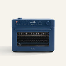 Wonder Oven Pro: Blue countertop oven with digital display for temp and time, top-left control knobs, and a clear front door revealing multiple racks inside.