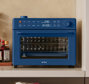 A blue Our Place countertop oven with a digital display showing 230 degrees and a 24:59 timer.