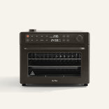 Wonder Oven Pro, a black countertop oven with digital controls and display, features two wire racks inside and is shown on a plain light background.