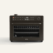 Wonder Oven Pro, a black countertop oven with digital controls and display, features two wire racks inside and is shown on a plain light background.