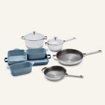 A Titanium Pro Cookware + Bakeware Set 2.0 featuring stainless steel pots with lids, two frying pans, and blue ceramic bakeware.