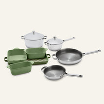 The Titanium Pro Cookware + Bakeware Set 2.0 features high-performance stainless steel cookware with lids and green ceramic bakeware on a checkered tray.