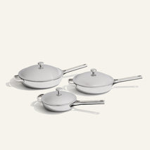Titanium Pro Always Pan Trio 2.0: three non-toxic stainless steel pans of varying sizes, each with a matching lid and long handle.