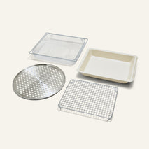 The Wonder Oven Pro Chef’s Kit includes a metal mesh basket, baking pan, round tray, and cooling rack as practical cooking inserts.