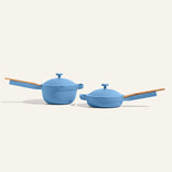 The Mini Cookware Duo features two blue multi-purpose pieces with wooden handles and matching lids, showcased on a plain, light background.