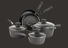 Set of black cookware including pots and pans on a dark background