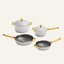 Titanium Pro Always Pan Trio 2.0 four-piece set of non-toxic titanium pans, consisting of two lidded pots and two frying pans with light gray finishes and gold-tone handles.