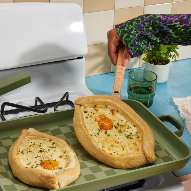 Cooking an egg pastry on a green Griddle Pan with green Oven Mats