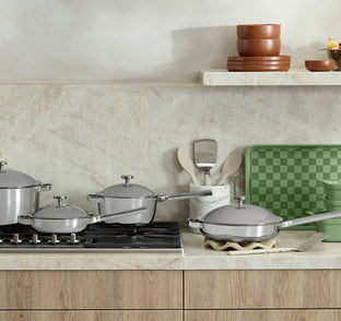 Set of titanium cookware on a kitchen counter with a neutral color scheme.