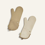 Pair of beige oven mitts on a light beige background