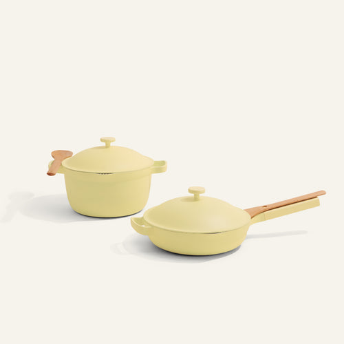 Two yellow cookware items with wooden handles on a white background