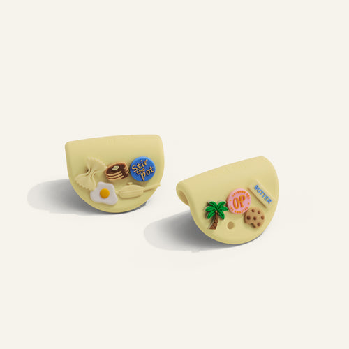Two yellow hot grips with decorative elements on a white background