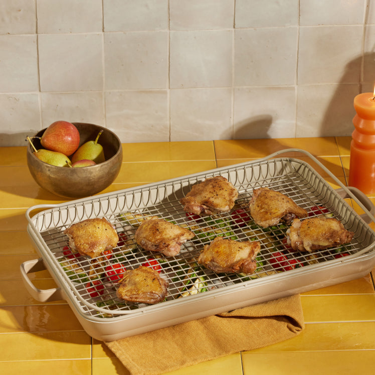 beige griddle pan and oven rack on counter with cooked chicken and vegetables