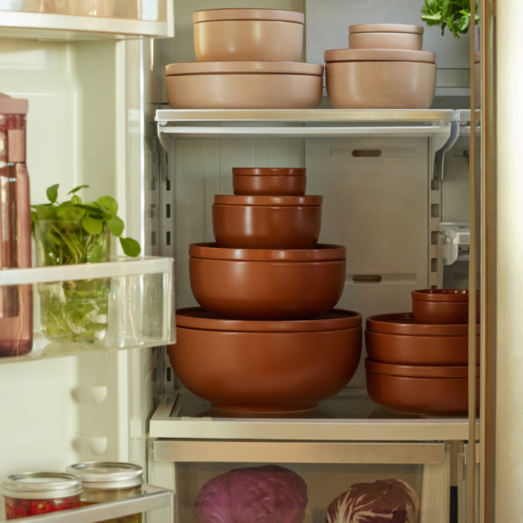 red and pink dinnerware stacked in fridge