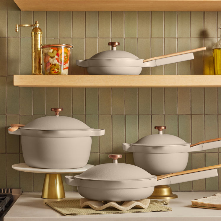 A set of beige Always Pans and Perfect Pots adorned with rose gold Metallic Knobs