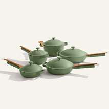 The Cookware Set+ features four green nonstick pots and pans with matching lids and wooden handles, all arranged on a plain light background.
