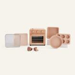 Set of toy kitchen appliances and utensils on a light beige background