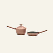 The Tiny Cookware Duo features two pink nonstick pieces—a saucepan with lid and a frying pan—shown against a plain light background.