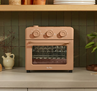 Peach-colored Our Place countertop oven on a kitchen counter.