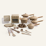 Beige kitchenware set including pots, pans, utensils, and an oven on a white background
