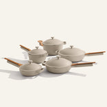 The Cookware Set+ includes five beige nonstick pots and pans with matching lids and wooden handles, displayed on a light background.