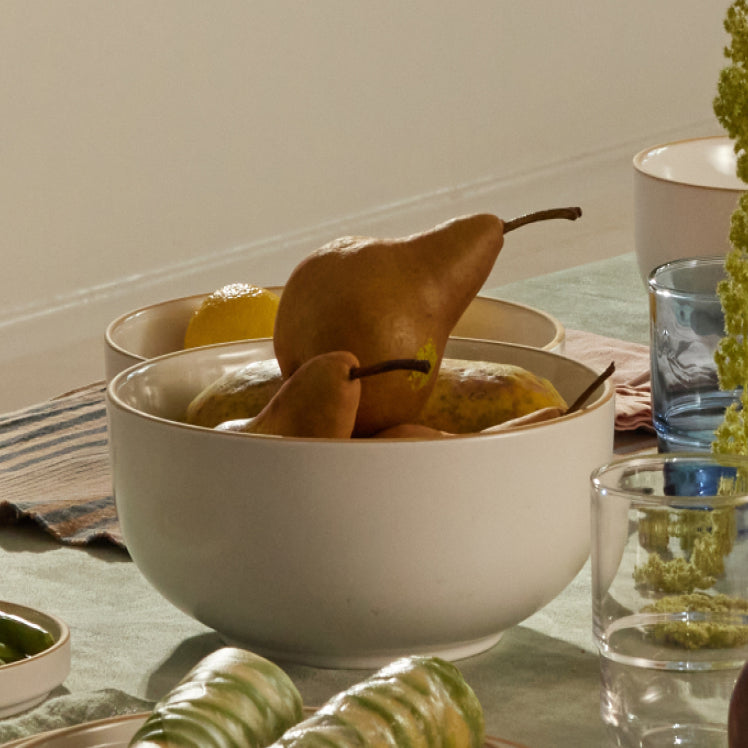 white serving bowls with fruit on table